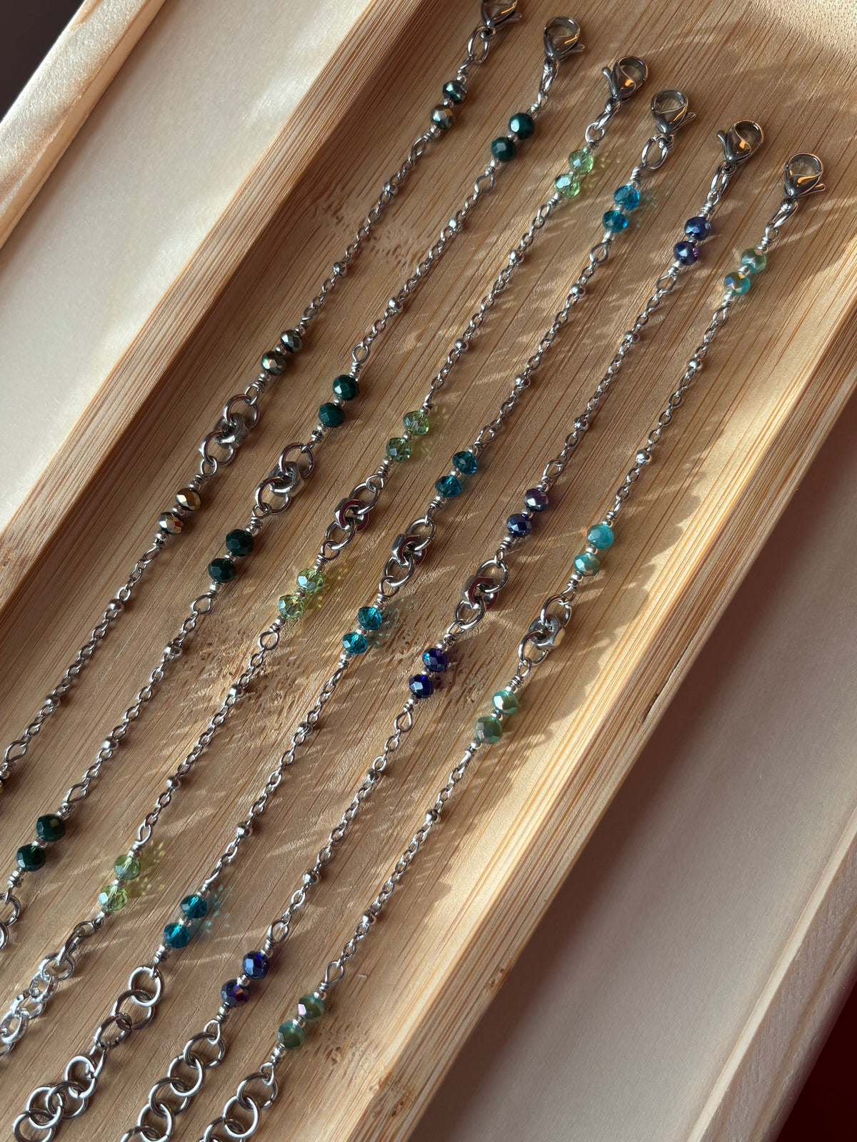 Bracciale in acciaio inox con dado centrale e cristalli colorati